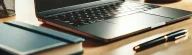 cropped-A-laptop-on-a-desk.-The-laptop-is-open-and-turned-on-displaying-a-bright-screen.-The-desk-is-tidy-with-a-few-items-such-as-a-notebook-a-pen-a-cup.webp